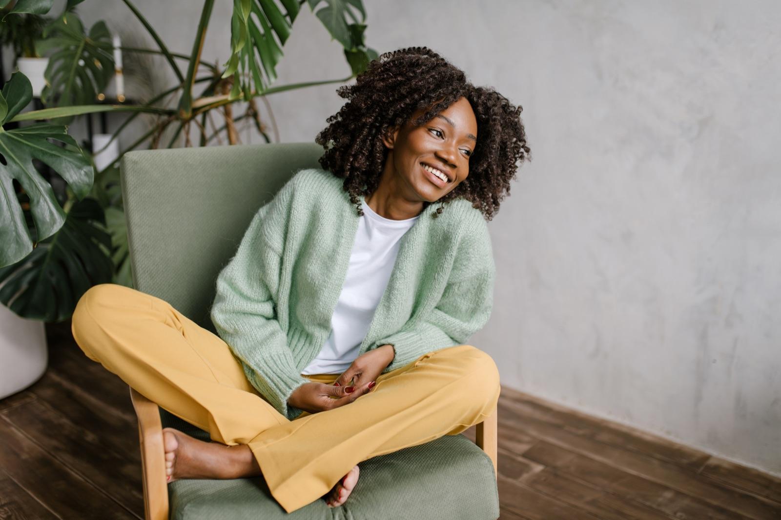 Woman sitting relaxed in a green chair, smiling